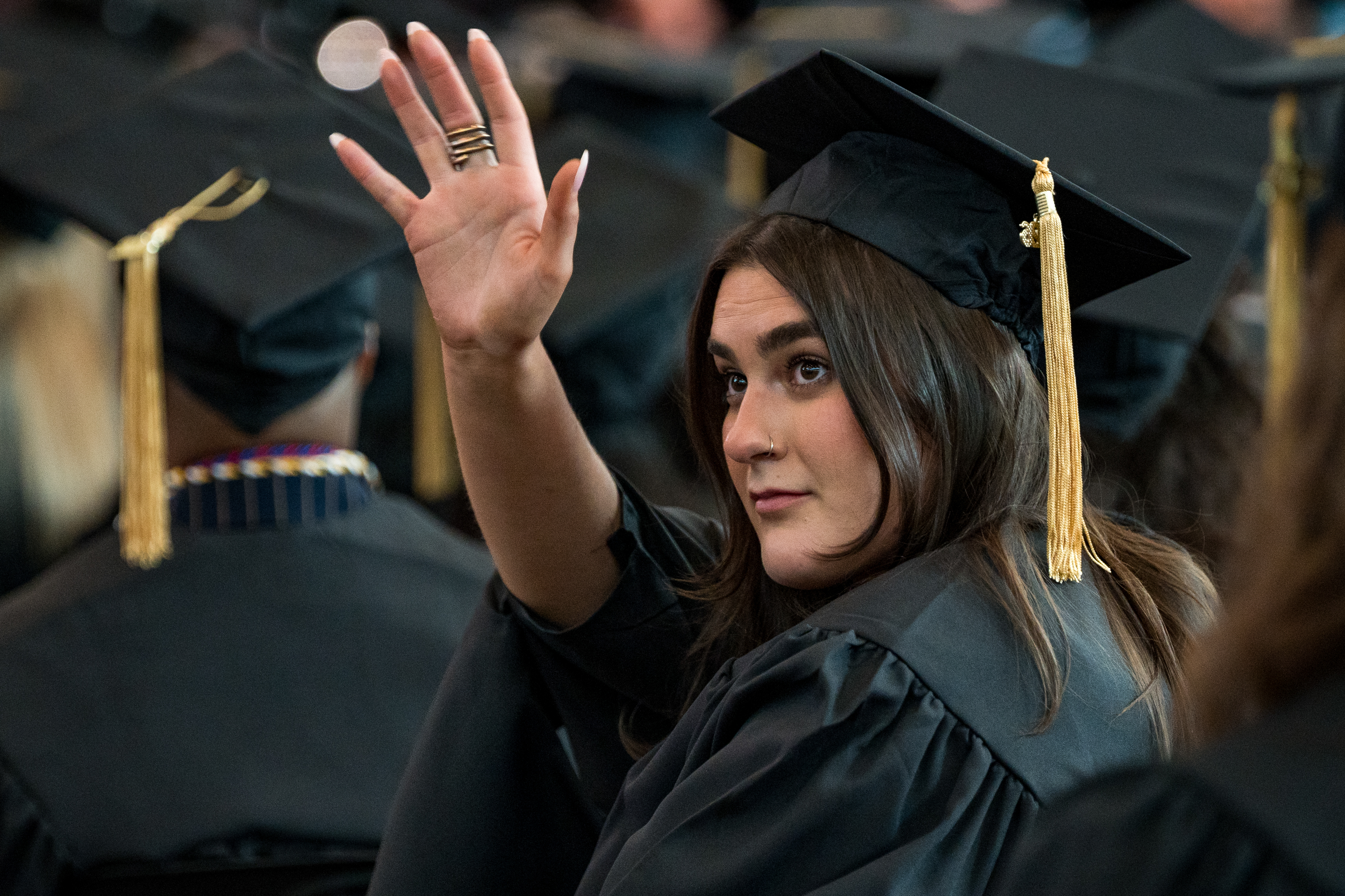 student waving at convocation